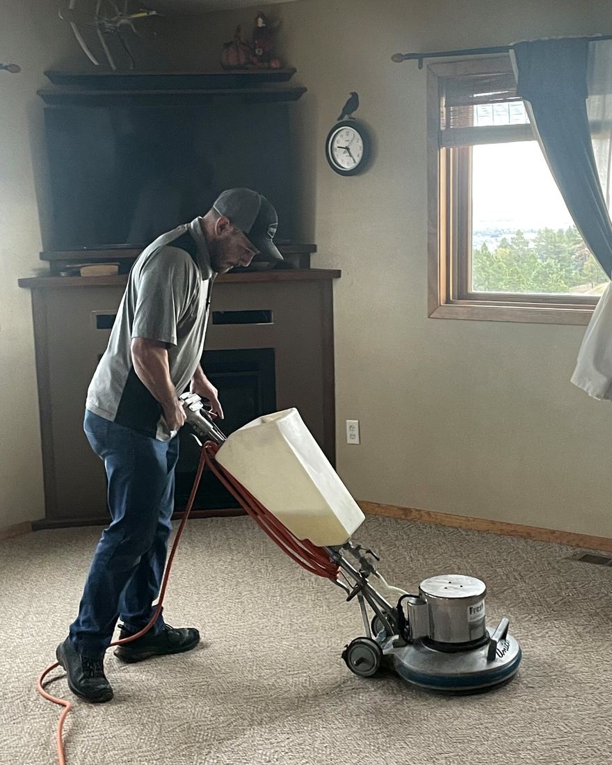 Fresh Start technician running a rotary scrubber on a living room carpet