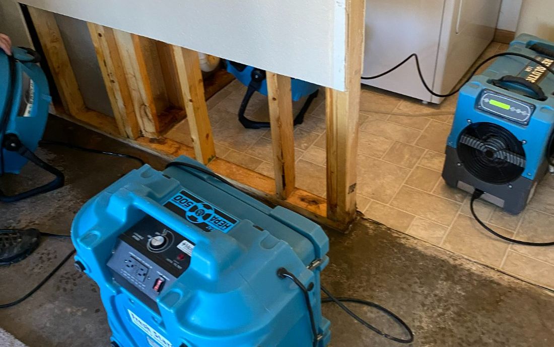 HEPA air scrubber running beside an opened wall during remediation